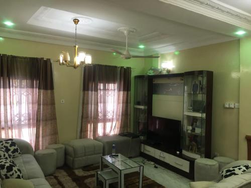 ein Wohnzimmer mit einem Sofa und einem großen TV in der Unterkunft KALSA Residence in Sukuta