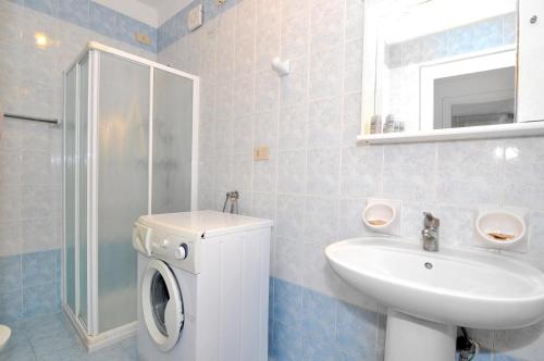een badkamer met een wastafel en een wasmachine bij Cristoforo Colombo in Caorle