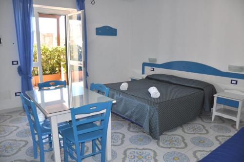 1 dormitorio con 1 cama, mesa y sillas en Villa Myremi en Ischia
