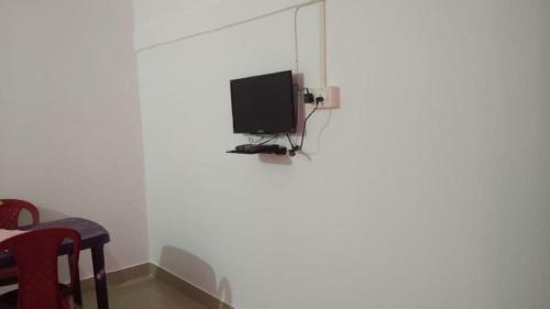 un televisor sentado en la esquina de una pared blanca en SREEMOYEE HOMESTAY, en Hatikhuli