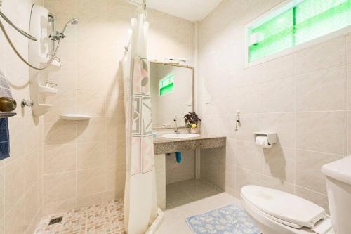 łazienka z toaletą i umywalką w obiekcie Baan Coconut w mieście Bang Tao Beach