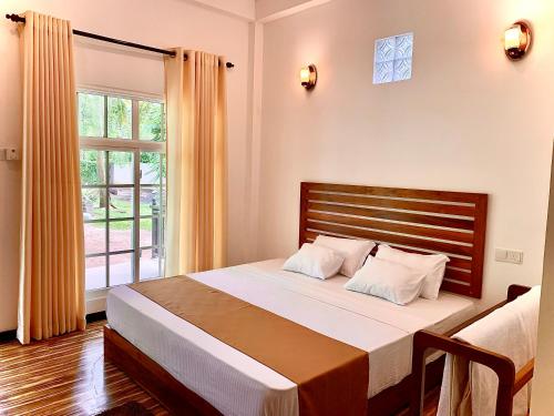 um quarto com uma cama grande e uma janela em Imperial Resort em Udawalawe