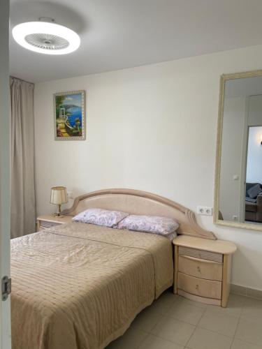 1 dormitorio con cama y espejo en Apartamento en Playa Flamenca (residencial El Rincon), en Playas de Orihuela