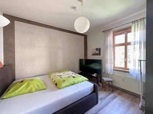 Un dormitorio con una cama con una manta amarilla. en Schöne Altbauwohnung mit großer Sonnenterrasse, en Rudolstadt