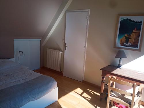 a bedroom with a bed and a desk with a lamp at Maison front de mer in Damgan