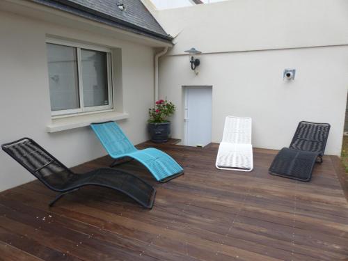 three chairs and a bench on a deck at Maison front de mer in Damgan