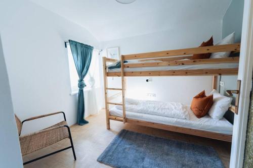 a bedroom with two bunk beds and a chair at Kuscheliges Häuschen in idyllischer Nachbarschaft in Innsbruck