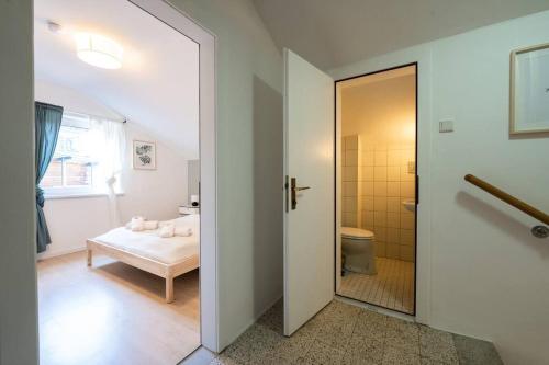 a room with a bathroom with a bed and a door at Kuscheliges Häuschen in idyllischer Nachbarschaft in Innsbruck