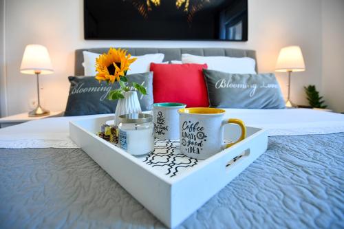 a tray with two cups and a vase on a bed at The Fairy's Cave in Dubrovnik