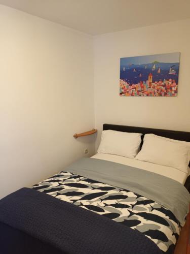 1 cama en una habitación con un cuadro en la pared en Apartments Dorcic, en Baška