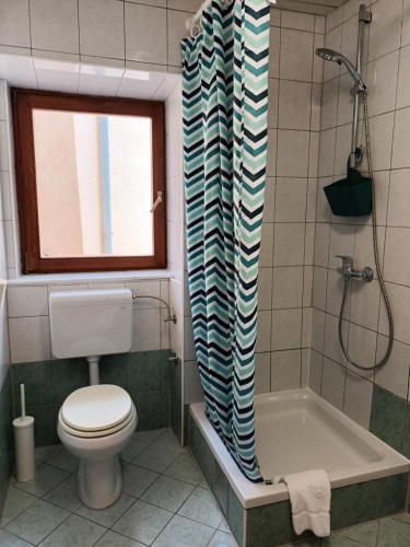 a bathroom with a toilet and a shower curtain at Apartments Dorcic in Baška