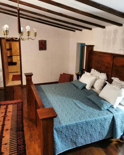 a bedroom with a large bed with a blue blanket at Vikendica Despotovic in Bijeljina