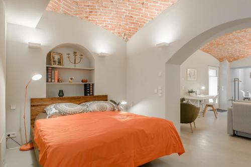 um quarto com uma cama laranja num quarto branco em Exklusiv: Historisches Apartment mit Deckengewölbe em Munique