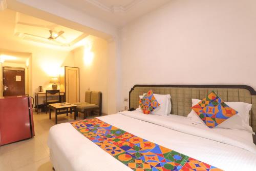 a bedroom with a large bed with colorful pillows at Hotel Mohan in Lucknow