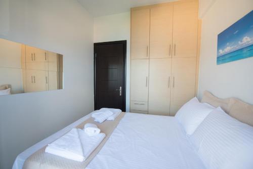 a bedroom with a white bed with towels on it at Amelia Villa in Nikiana