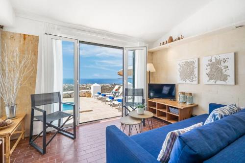 a living room with a blue couch and a view of the ocean at Sa Calma in Cala Blanca