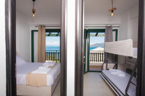 a bedroom with a bed and a balcony with the ocean at Amelia Villa in Nikiana