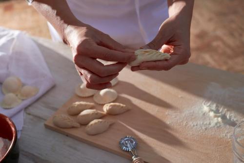 a person is kneading dough on a cutting board at Cascioni Eco Retreat in Arzachena