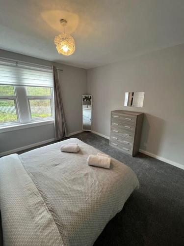 a bedroom with a large bed with two towels on it at Cosy Cottage Apartment in Helensburgh