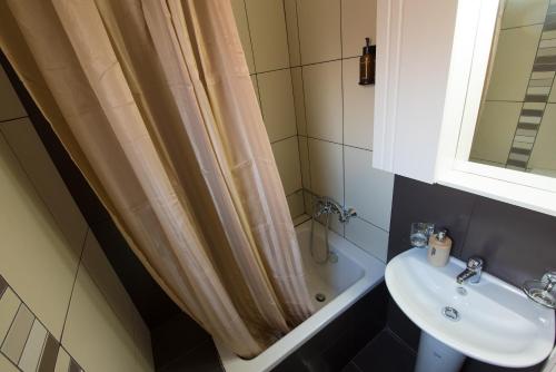 a bathroom with a shower curtain and a sink at Amelia Villa in Nikiana