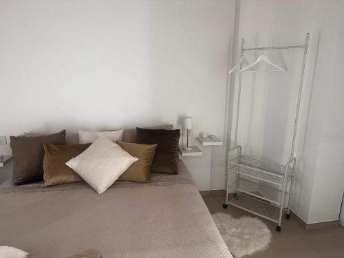 a bed in a white room with pillows on it at Eterea Casa Vacanza in Brindisi