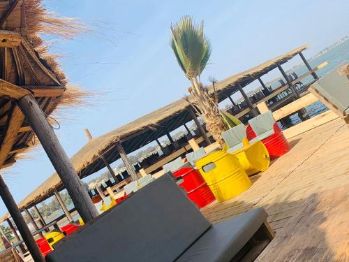 Hotel le Trarza في نياغا: مجموعة من الكراسي الملونة وطاولة على الشاطئ