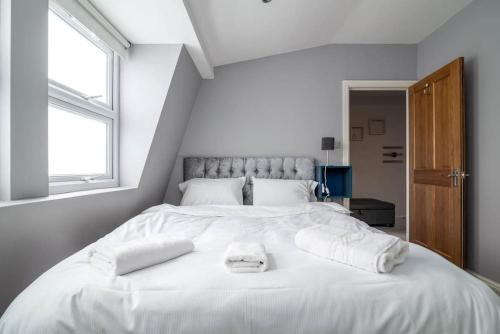 a large white bed with two towels on it at Luxury Apartment located near Marble Arch & Baker Street in London