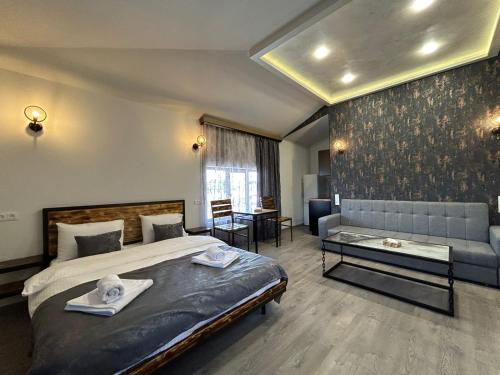 - une chambre avec un lit, un canapé et une table dans l'établissement WaterFall Hotel, à Erevan