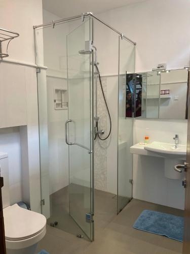 Un baño con ducha, inodoro y lavabo. en Suriya Arana, en Negombo