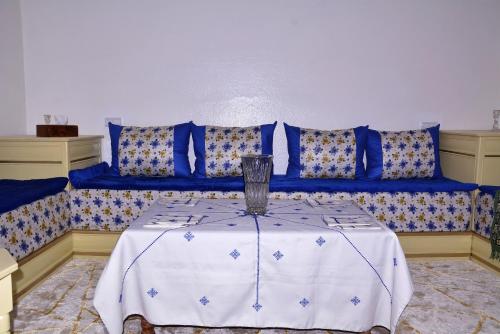 a living room with a blue couch with a table at Chez zoubida in Meknès