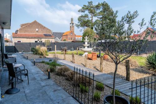 a garden with a fountain and a fence at Hotel Rooms in Breskens