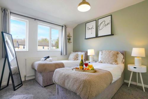 ミルトン・キーンズにあるCentral MK House with Free Parking, Fast Wifi, and Smart TV with Xbox, Sky TV Packages and Netflix by Yoko Propertyのベッドルーム1室(ベッド2台、ワイン1本付きのテーブル付)