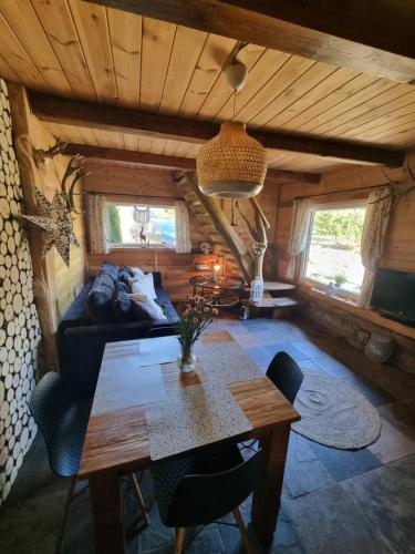 uma sala de estar com uma mesa e um sofá em Wiejska Chata em Barczewo