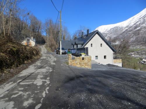 an empty road with a house and a snow covered mountain at Domaine Du Sauveur in Luz-Saint-Sauveur
