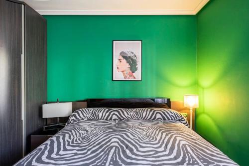 Un dormitorio con una pared verde y una cama en Pop Gallery en León