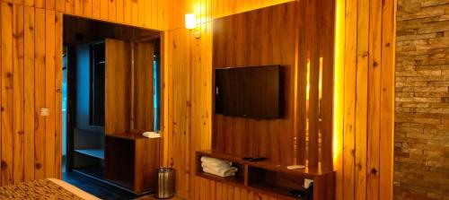 a room with a television on a wooden wall at Qcent Woods Resort & Spa, Rishikesh in Rishīkesh