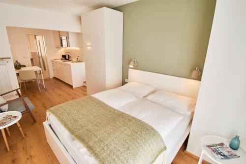 ein Schlafzimmer mit einem großen weißen Bett in einem Zimmer in der Unterkunft Residence Isarcus in Brixen