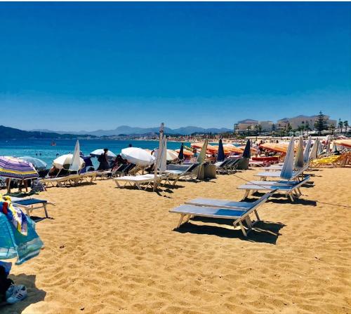 a beach with chairs and umbrellas and the ocean at Playa del Pasha in Restinga Smir