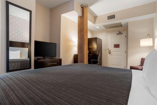a hotel room with a bed and a flat screen tv at Best Western Plus St. Christopher Hotel in New Orleans