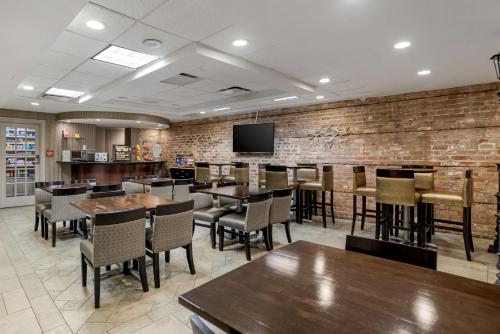 a restaurant with tables and chairs and a brick wall at Best Western Plus St. Christopher Hotel in New Orleans