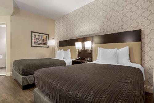 a hotel room with two beds with white pillows at Best Western Plus St. Christopher Hotel in New Orleans