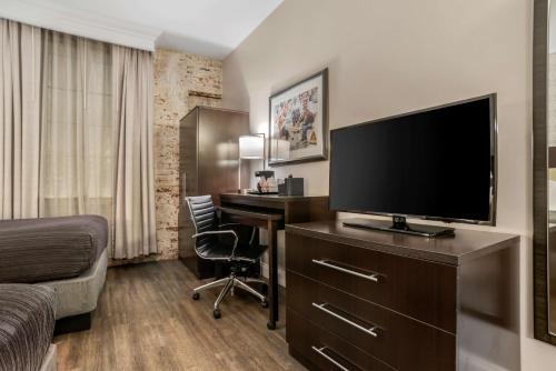 a hotel room with a desk and a flat screen tv at Best Western Plus St. Christopher Hotel in New Orleans