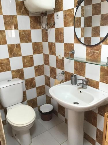 a bathroom with a toilet and a sink at Résidence Keur Fleurie in Toubab Dialaw
