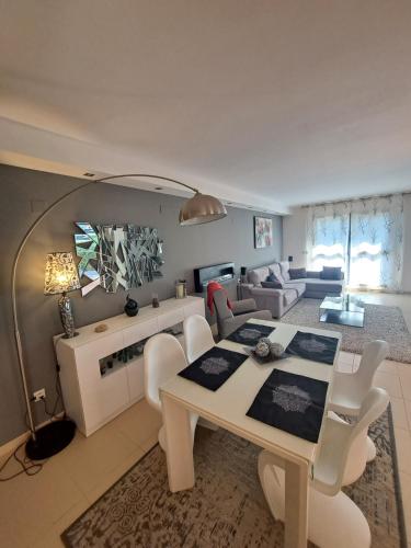 sala de estar con mesa blanca y sillas en Villa Panorámica, en Sant Jordi