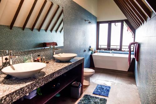 a bathroom with two sinks and a tub and a toilet at Villa Jado 3 - Lake and Mountain View Villa in Bedugul
