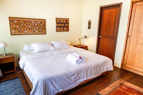 a bedroom with a white bed with towels on it at Villa Jado 3 - Lake and Mountain View Villa in Bedugul