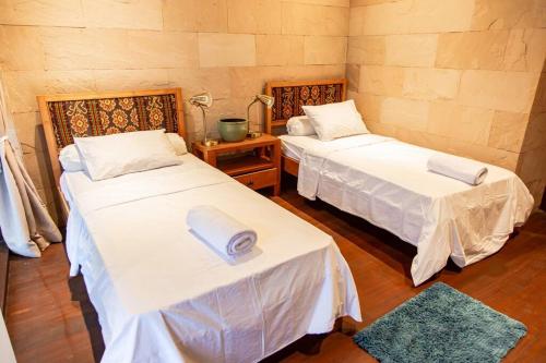 a room with two beds and a table at Villa Jado 3 - Lake and Mountain View Villa in Bedugul