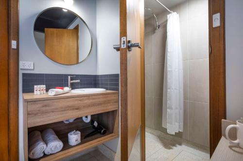 a bathroom with a sink and a mirror and a shower at Nightcap at Empire Hotel in Gepps Cross