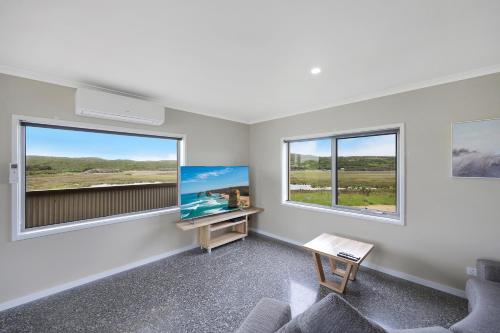 a living room with two windows and a desk at Otway Coastal Villas, 1 Bedroom villa. in Princetown
