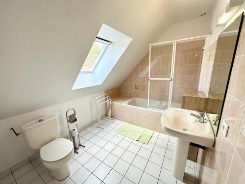 La salle de bains est pourvue de toilettes, d'un lavabo et d'une douche. dans l'établissement Maison de vacances – Jardin – 5 min des plages, à Guidel